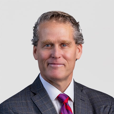 Jon Langenfeld professional headshot with gray background.