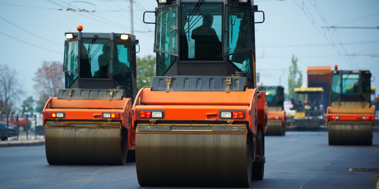Large pavement equipment driving down a new road.